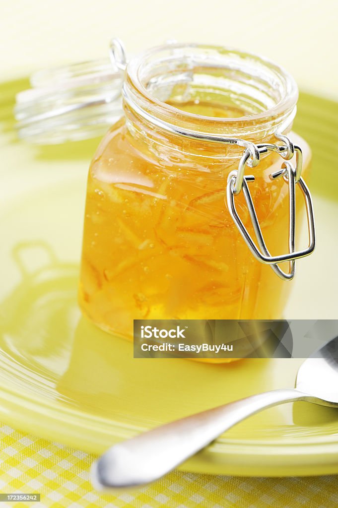 Marmalade Open jar of marmalade and spoon on a yellow background. Food Stock Photo