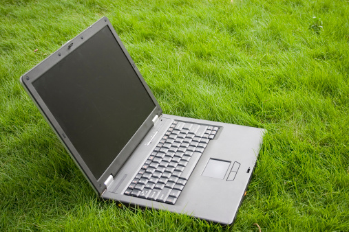 Laptop lying on a grass