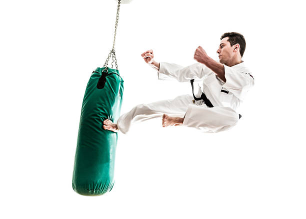 jeune homme pratiquant le arts martiaux - karate punching bag caucasian leisure activity photos et images de collection