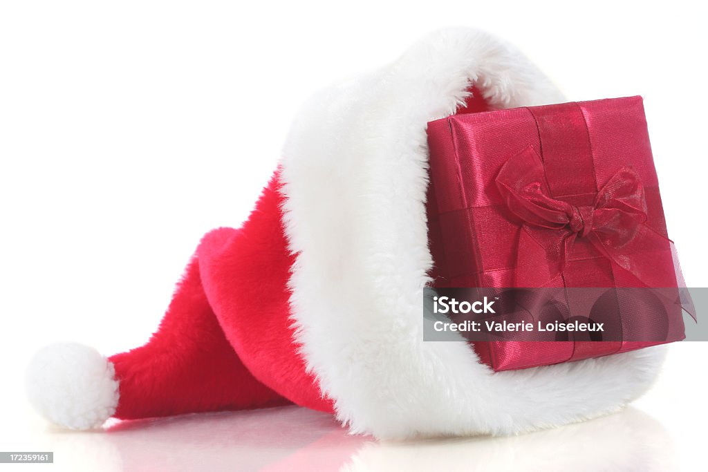 Christmas present in Santa hat A christmas present in a santa hat. Great for Christmas concept. Box - Container Stock Photo