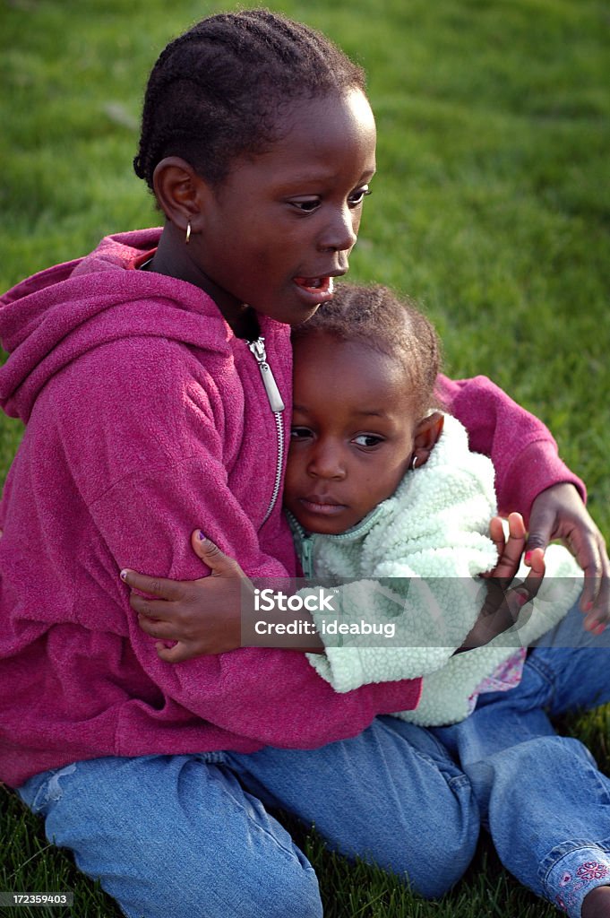 Due bambine abbracciare l'altro al di fuori - Foto stock royalty-free di 2-3 anni