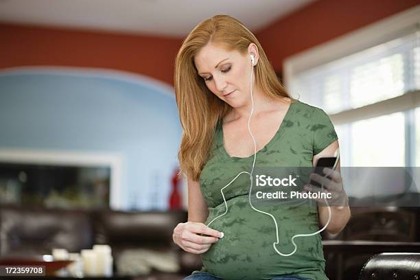Mujer Embarazada Escuchar Música En Su Hogar Foto de stock y más banco de imágenes de 30-34 años - 30-34 años, 30-39 años, Abdomen