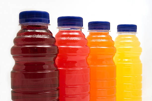 Four different juice bottles in a row with white background stock photo
