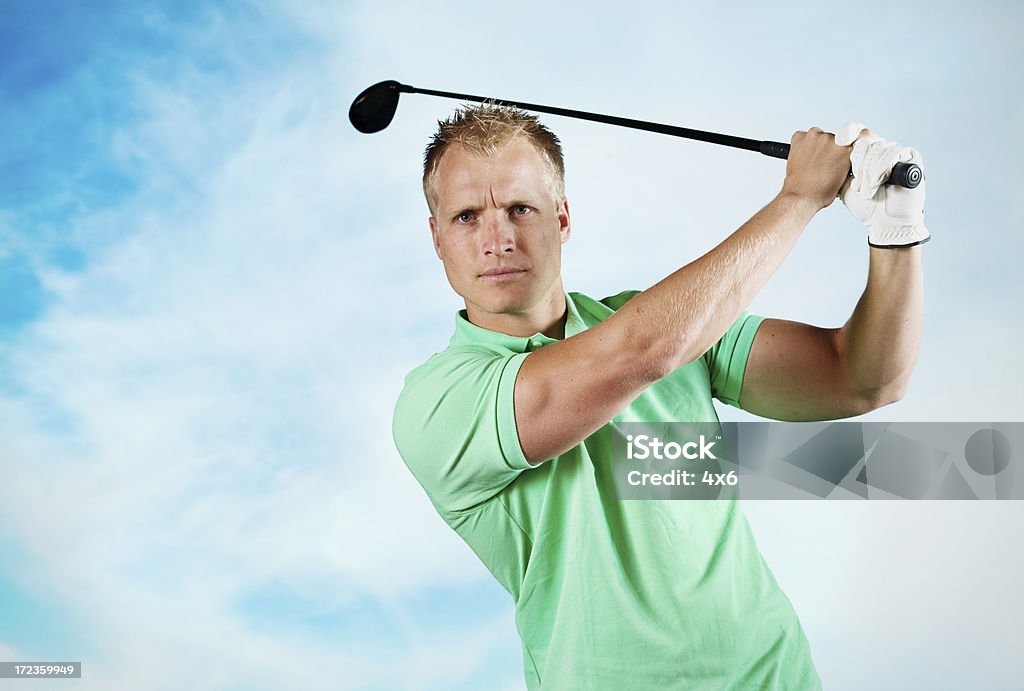 Macho con un golfista Balanceo de golf club - Foto de stock de Columpiarse libre de derechos