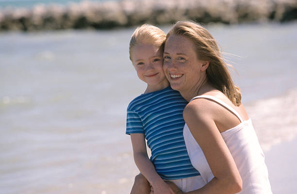 istock Mother and daughter smiling on beach 172360005