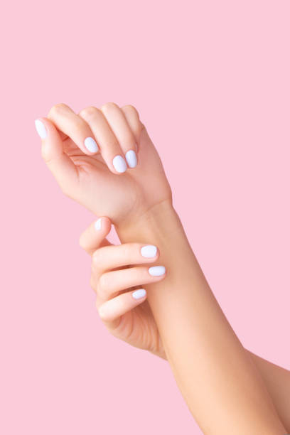 istock Womans hands with white manicure on pink background 1723600313