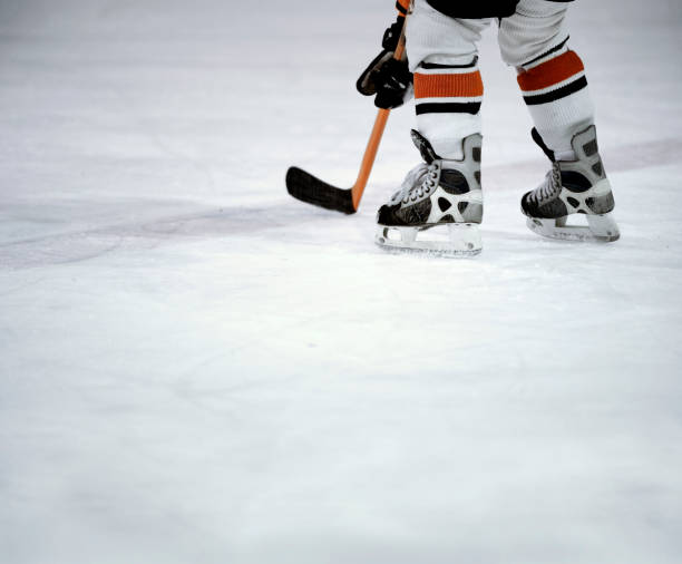 Skates on ice "Hockey player skates and stick on ice, with copy spacePlease see more of my" hockey skates stock pictures, royalty-free photos & images
