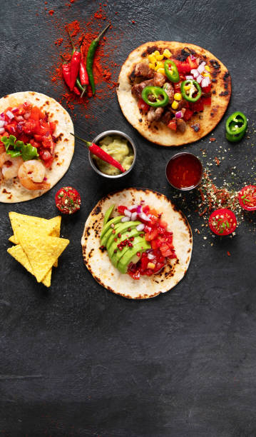 istock Tacos with salsa, vegetables and avocado on black background 1723604956