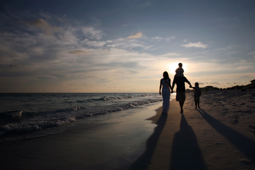 A family walks along the waters edge during a wonderful sunset - So relaxing!