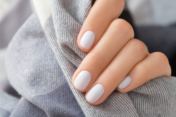 istock Womans hand with white nail design holding fabric 1723608837