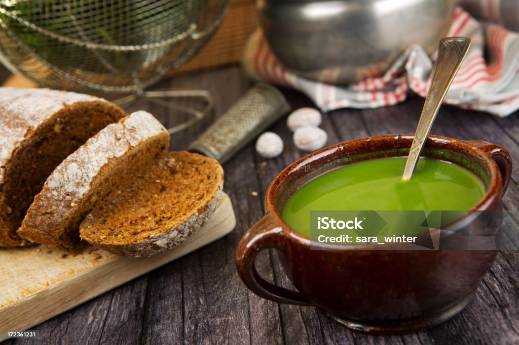 Vert soupe dans un bol sur une table rustique - Photo de Soupe de petits pois libre de droits