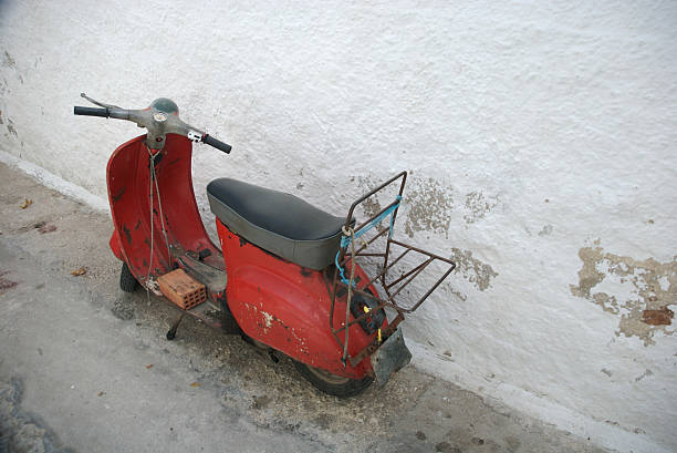 istock Old Red Scooter Parked Next to Weathered White Wall 172361273