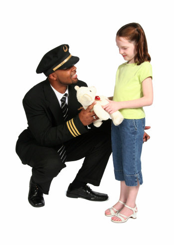 Young pilot helps a young passenger feel better by giving her a teddy bear