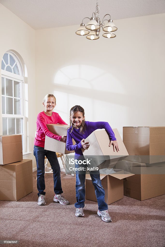 Duas meninas ajudar a mover as caixas de seleção - Foto de stock de 6-7 Anos royalty-free