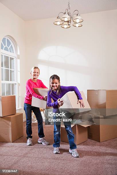 Foto de Duas Meninas Ajudar A Mover As Caixas De Seleção e mais fotos de stock de 6-7 Anos - 6-7 Anos, 8-9 Anos, Assistência