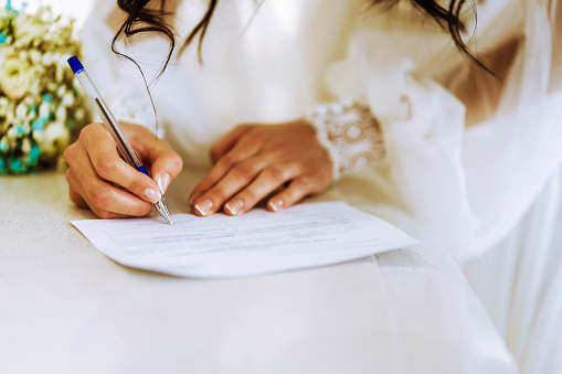 Bride write on registration of Marriage, Woman signing a marriage Contract, close-up