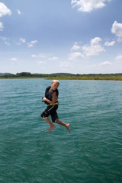 camminare sull'acqua - life jacket little boys lake jumping foto e immagini stock