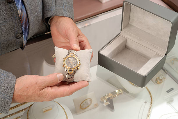 Buying a wristwatch Salesman showing a luxury wristwatch at jewelry´s store. More from this jewelry store in the lightbox: jewelry store stock pictures, royalty-free photos & images