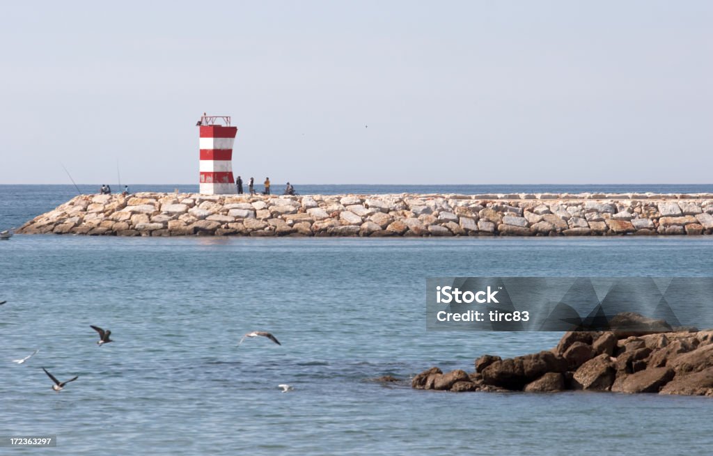 People on breakwater Quarteira Stock Photo