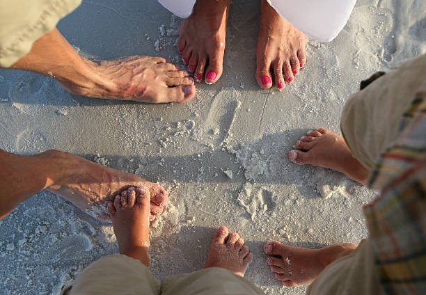 Feet from Family of four Family of four hang out at the beach standing toe to toe. big family sunset stock pictures, royalty-free photos & images