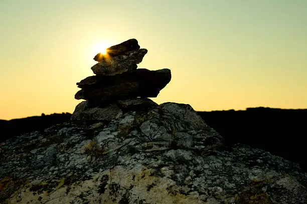 "It is a norwegian tradition to collect rocks along a hiking route to guide fellow hikers the right way to the top of the mountain, also called a cairn. The image is shot just before midnight, and the midnight sun is just behind the pile."