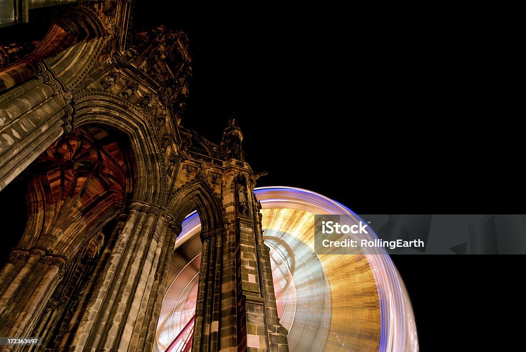 Scott Monument and Ferris Wheel "A ferris wheel light's up the night sky behind the Scott Monument in the heart of Edinburgh, UK." Edinburgh - Scotland Stock Photo