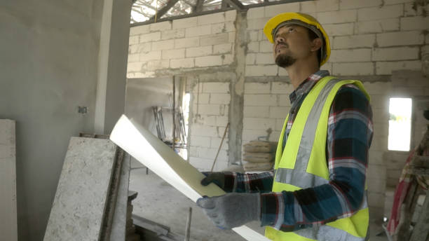 istock Asian architect reviewing blueprints in the project Construction home  at Construction site. 1723642134