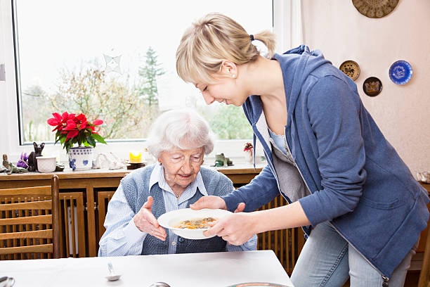 prestador de sopa de servir a terceira lady - senior adult nursing home eating home interior imagens e fotografias de stock