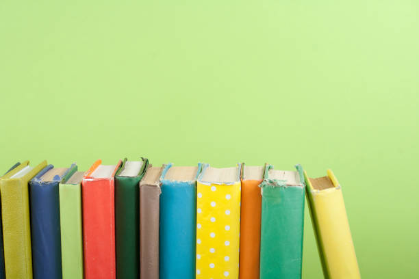 istock Book stacking. Open hardback books on wooden table and green background. Back to school. Copy space for ad text. 1723646807