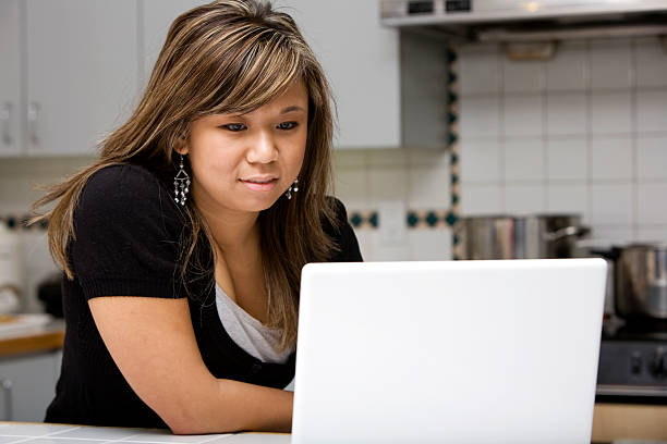 istock Young stylish woman using her laptop in her kitchen 172364704