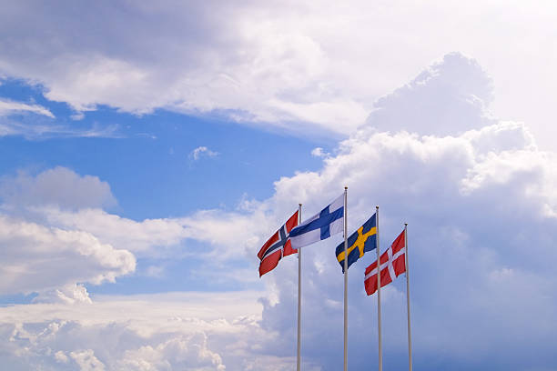 nordic flags "flags of the nordic (scandinavian) countries of (left to right) norway, finland, sweden and denmark against a dramatic sky." scandinavian ethnicity stock pictures, royalty-free photos & images