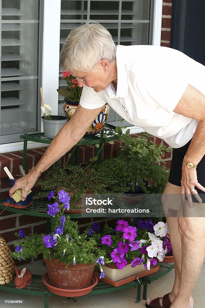 watering senior watering her plants 80-89 Years Stock Photo