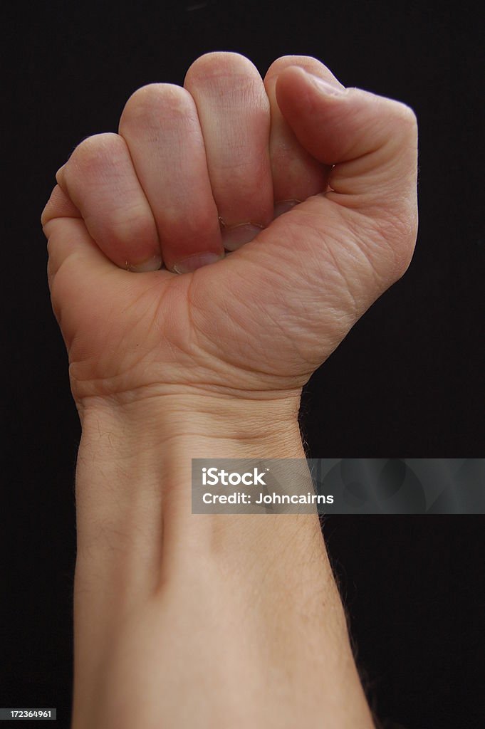 Fist of Power. Clenched fist against black background. Anatomy Stock Photo