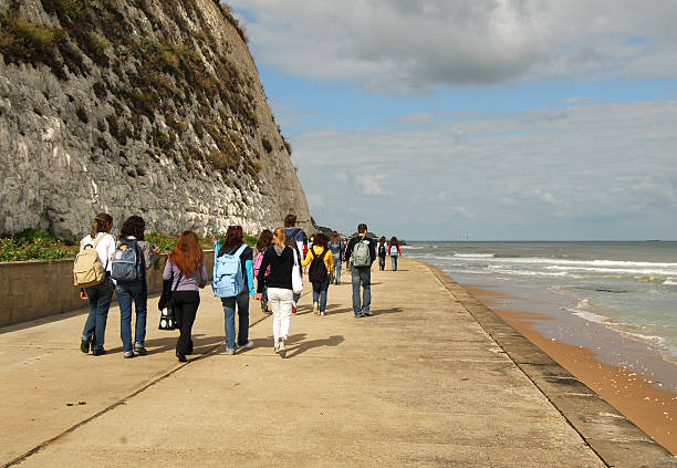 Group of Students Walking the Foreshore, Kent A group of foreign student visitors walking along the foreshore at Broadstairs in Kent, England. thanet photos stock pictures, royalty-free photos & images
