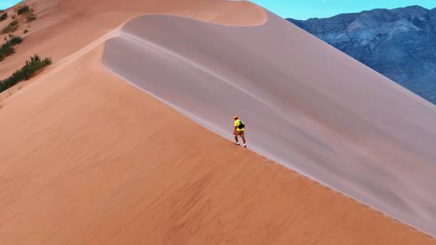 istock Man walking on the dune of the desert 1723668221