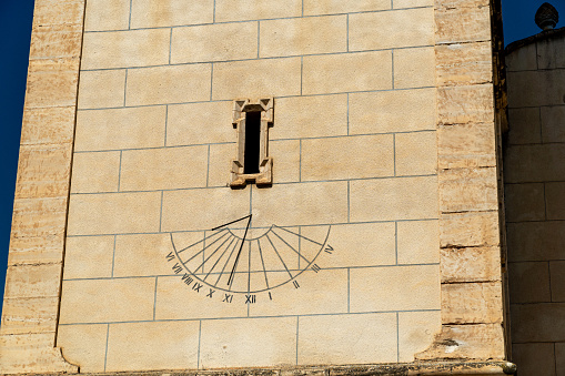 Sundial in the stone facade of a church