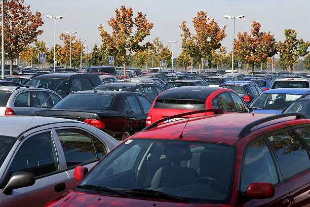 Photo of The tops of many rows of cars in a parking lot with trees