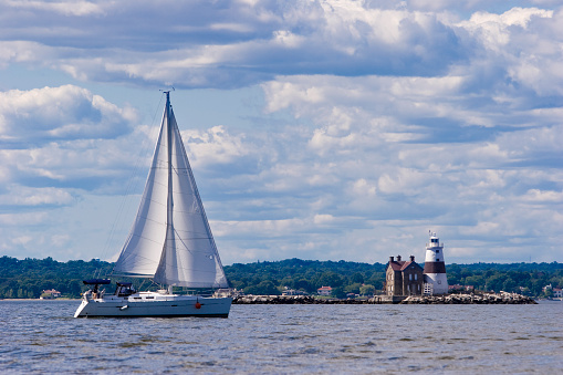 Sailboat passes Execution Rocks Light, on an island in Long Island Sound (New York). Photo taken from boat.