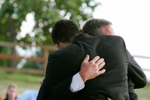 Loving Hug Between Friends / Father and Son Two men hug each other. Horizontal with copy space. mercy hug stock pictures, royalty-free photos & images