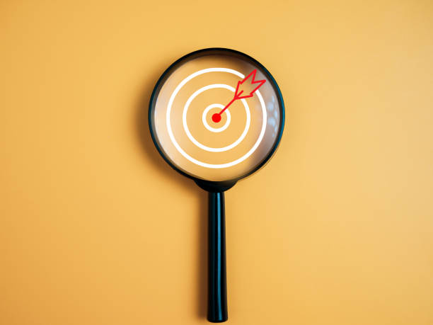 istock Target, objective, Goal achievement, Purposefulness concept. Magnifying glass focus on dartboard icon over yellow background. 1723694730