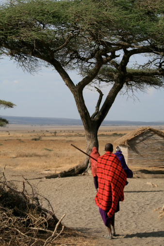 two women followed by a Masai warrior