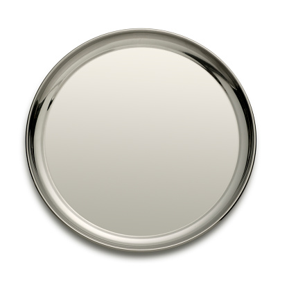 A round silver tray isolated on a white background. A light gray tone across the serving tray allows ample room for copy. A soft shadow sits under the tray.