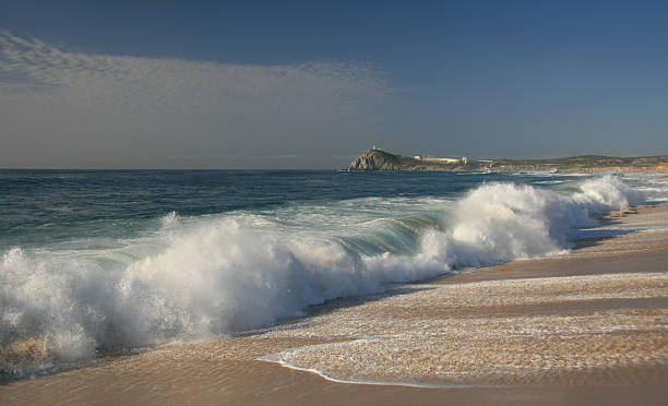 istock Waves crashing onto sandy beach under cloudy sky. 172370375