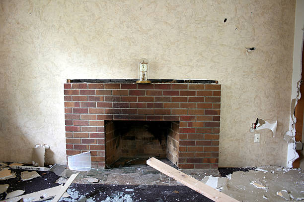 Abandoned damage strewn room with clock on fireplace mantle Crumbling sheetrock and aged wallpaper frame an old brick fireplace. I've more drywall fireplace stock pictures, royalty-free photos & images