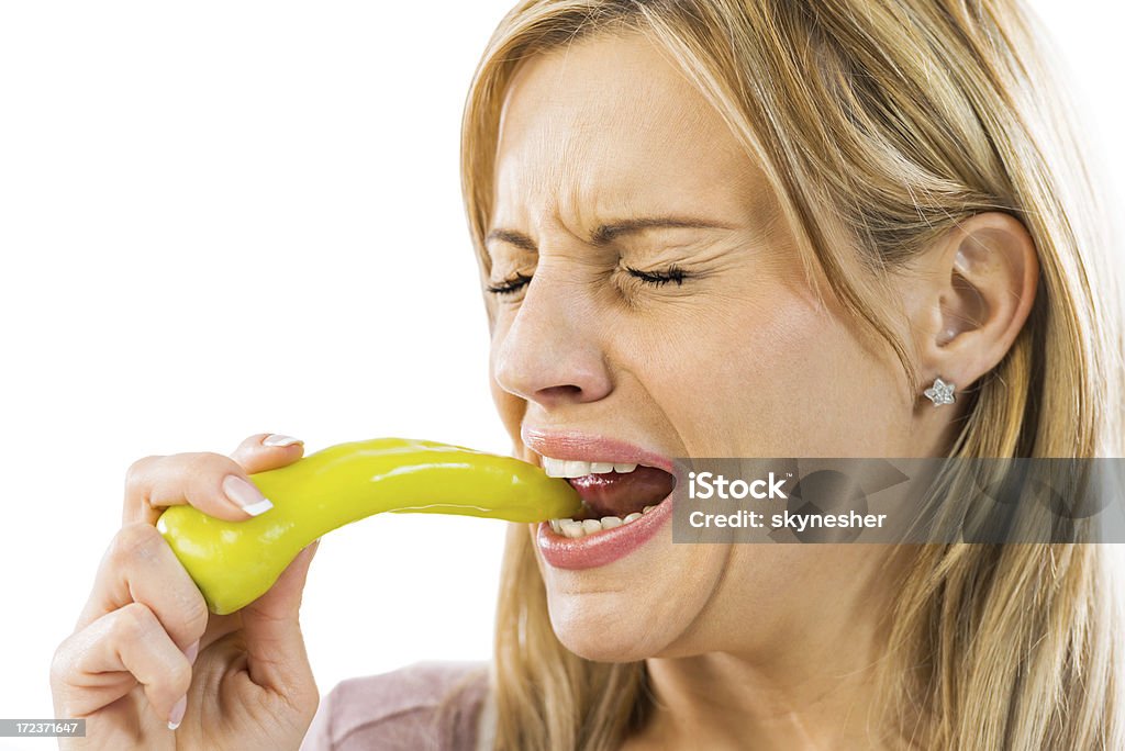 Gros plan d'une femme Manger le piment. - Photo de Fond blanc libre de droits
