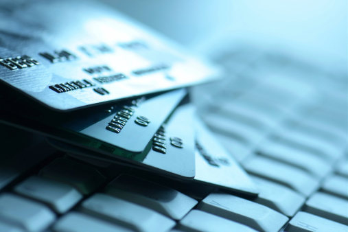 Macro of four credit cards on a computer keyboard. Blue hue. You may also like: 