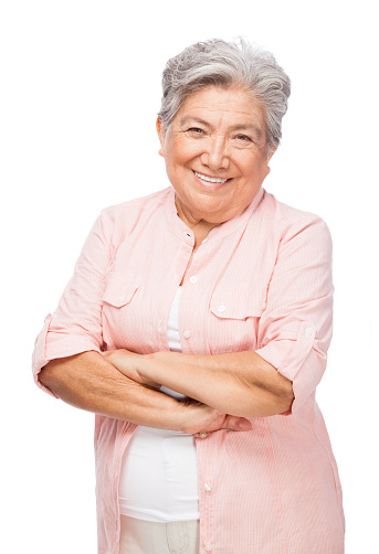 Portrait of senior, happy and cheerful woman standing against a red studio background. Mature woman with healthy, white and clean teeth showing oral and dental health with a friendly bright smile
