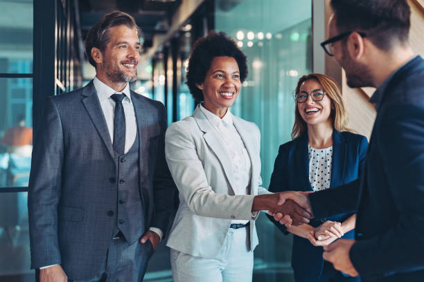 Happy to be part of a successful team Group of business persons shaking hands in the office global business handshake stock pictures, royalty-free photos & images