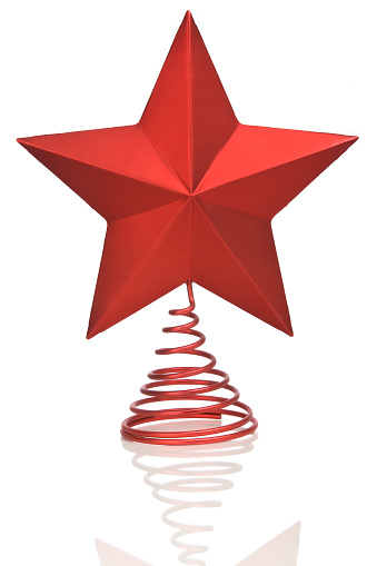 A bright red Christmas star on a reflective surface.
