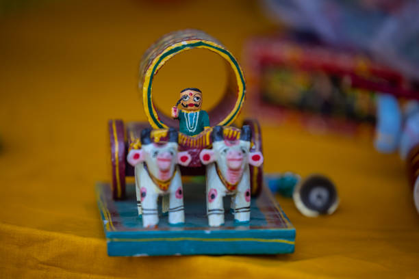 Handmade wooden art of hindu farmer with bull cart idol on display at surajkund craft fair.